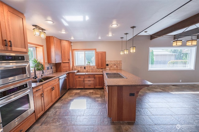 kitchen with a breakfast bar, pendant lighting, sink, stainless steel appliances, and backsplash