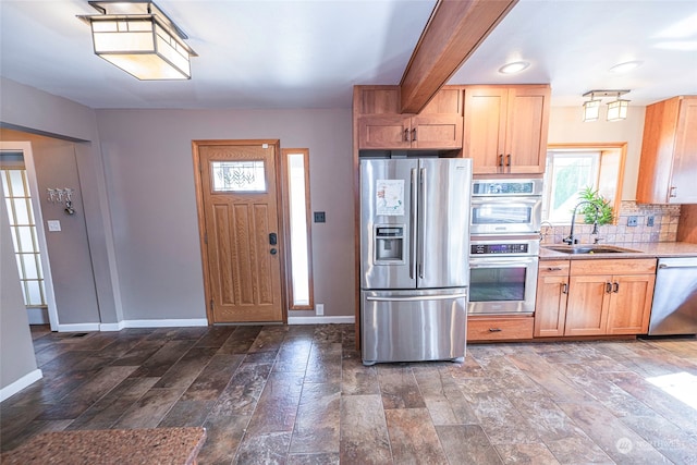 kitchen with appliances with stainless steel finishes, tasteful backsplash, dark wood-type flooring, and sink