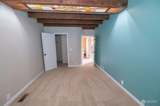 carpeted spare room featuring beam ceiling