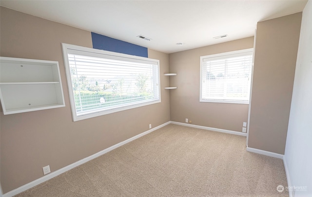 carpeted spare room featuring a wealth of natural light