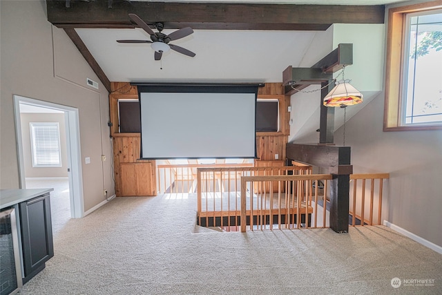 carpeted cinema featuring ceiling fan and lofted ceiling with beams