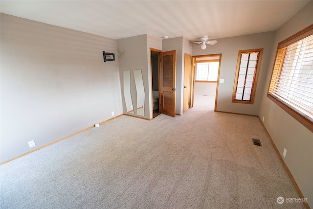 empty room with ceiling fan and light colored carpet