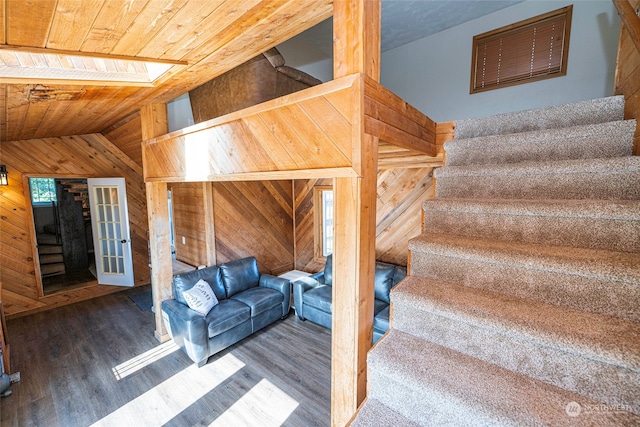 stairs featuring hardwood / wood-style flooring, wooden walls, vaulted ceiling, and wooden ceiling