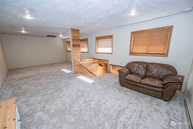 living room featuring a textured ceiling, light colored carpet, and baseboard heating