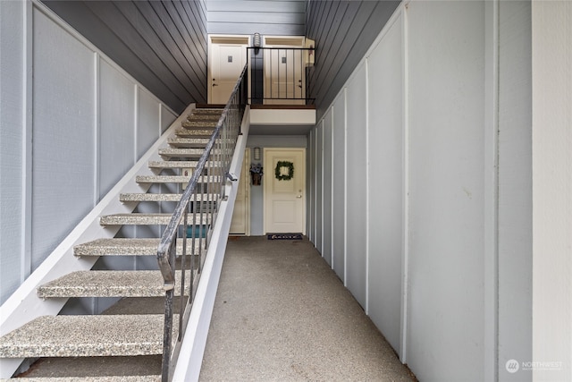 staircase featuring wood walls