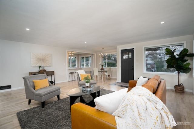 living room with light wood-type flooring and a chandelier