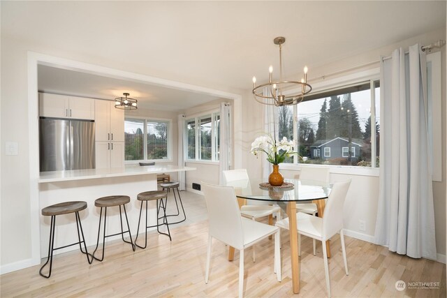 4109 N Huson St, Tacoma, WA 98407 - dining area featuring a chandelier, baseboards, and light wood-type flooring