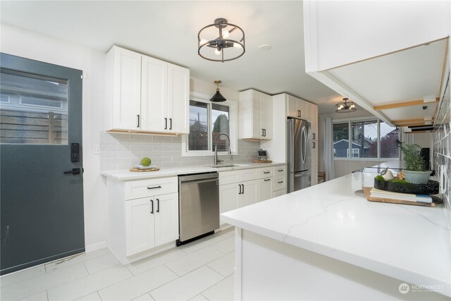 4109 N Huson St, Tacoma, WA 98407 - kitchen featuring white cabinetry, appliances with stainless steel finishes, decorative backsplash, and a sink