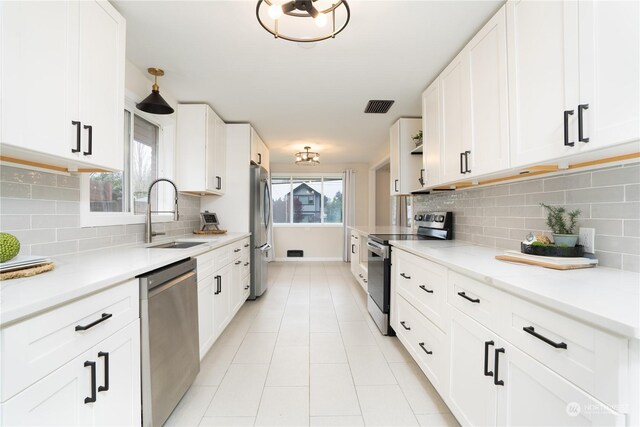 4109 N Huson St, Tacoma, WA 98407 - kitchen featuring light tile patterned floors, a sink, white cabinetry, visible vents, and appliances with stainless steel finishes