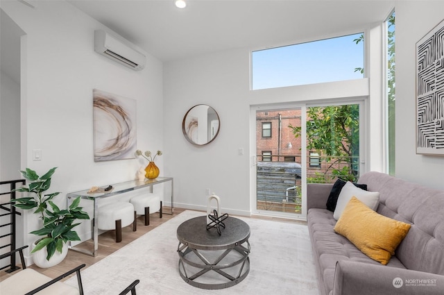 living room with a wall mounted AC and light hardwood / wood-style flooring