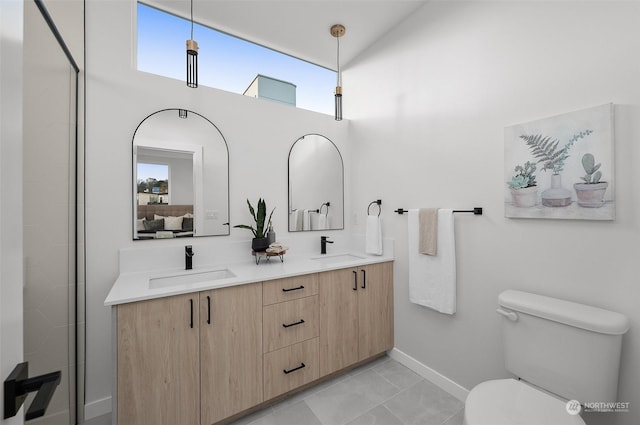 bathroom with vanity, a high ceiling, and toilet