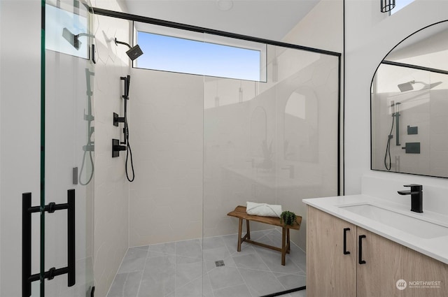 bathroom featuring tile patterned flooring, vanity, and walk in shower