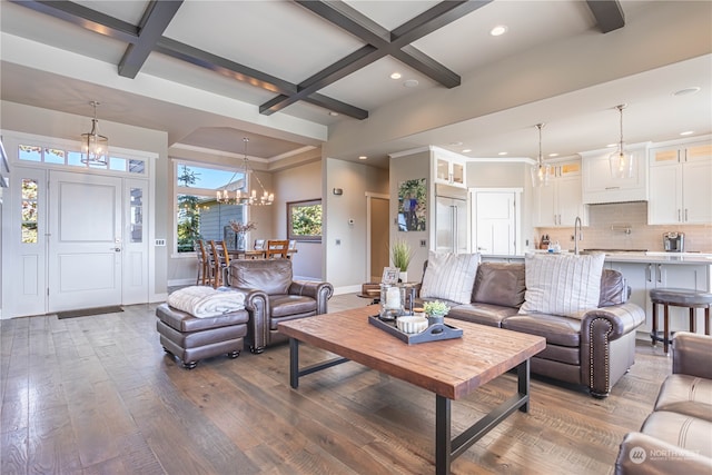 living room with a notable chandelier, sink, coffered ceiling, dark hardwood / wood-style floors, and beam ceiling