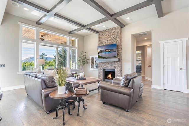 living room with beamed ceiling, coffered ceiling, hardwood / wood-style flooring, and a fireplace