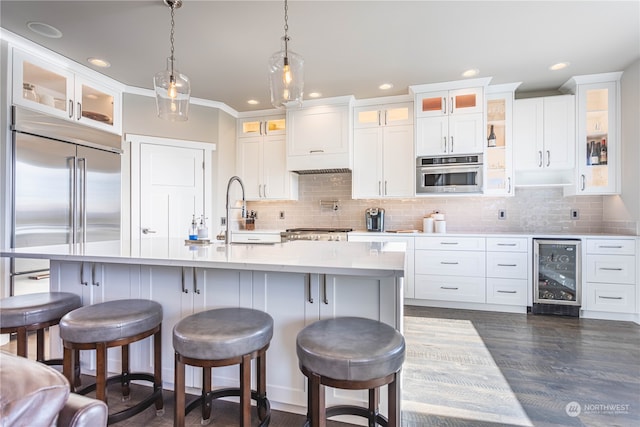 kitchen with dark hardwood / wood-style flooring, hanging light fixtures, ornamental molding, appliances with stainless steel finishes, and wine cooler