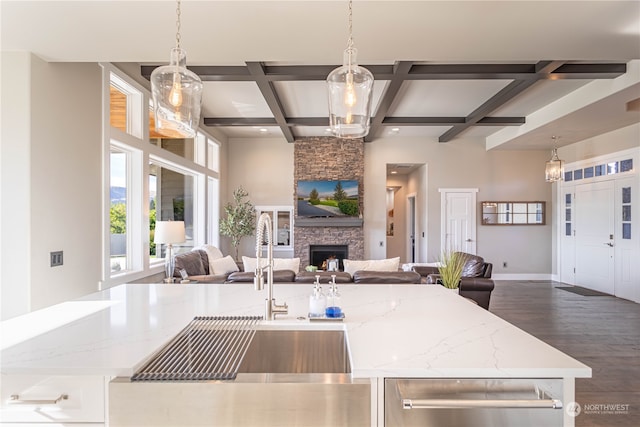 kitchen with pendant lighting, dark hardwood / wood-style floors, light stone counters, and coffered ceiling