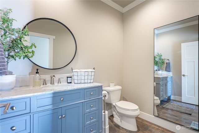 bathroom featuring hardwood / wood-style flooring, vanity, toilet, and crown molding