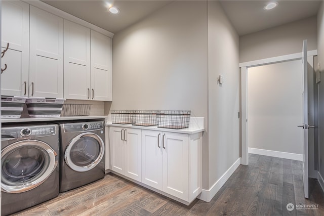 laundry area with hardwood / wood-style floors, cabinets, and independent washer and dryer