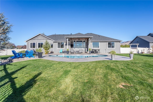 back of house with a fenced in pool, a yard, and a patio area