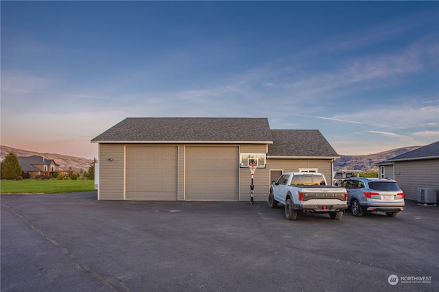 view of front of home with a mountain view, a garage, and central AC