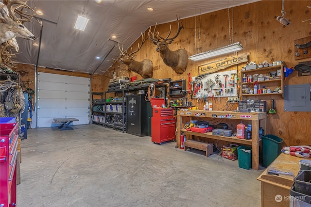 garage with a workshop area and wooden walls