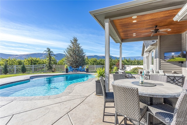 view of pool with a patio area, a mountain view, and ceiling fan