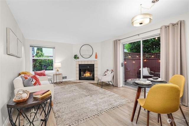 living room with light hardwood / wood-style floors and a tile fireplace