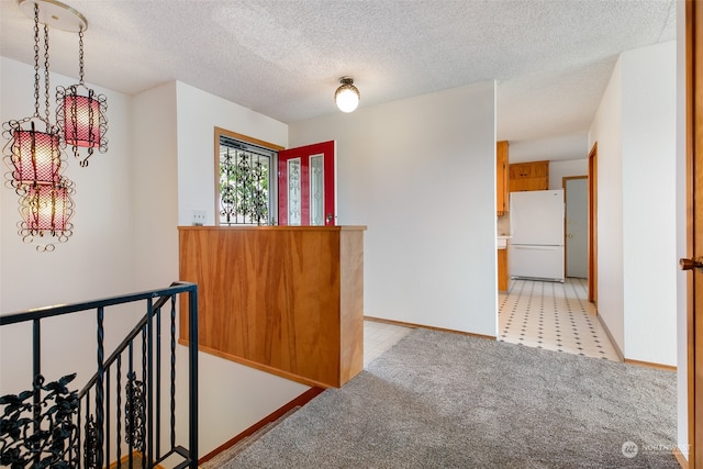 hall featuring a textured ceiling and light carpet