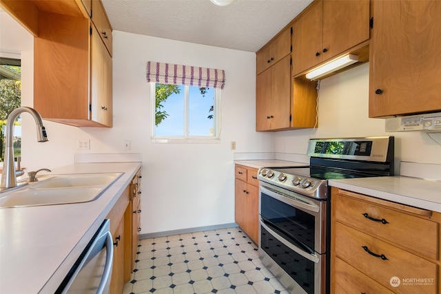 kitchen with appliances with stainless steel finishes, a textured ceiling, and sink