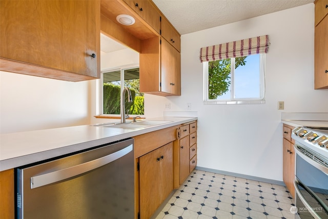 kitchen featuring a textured ceiling, appliances with stainless steel finishes, and sink