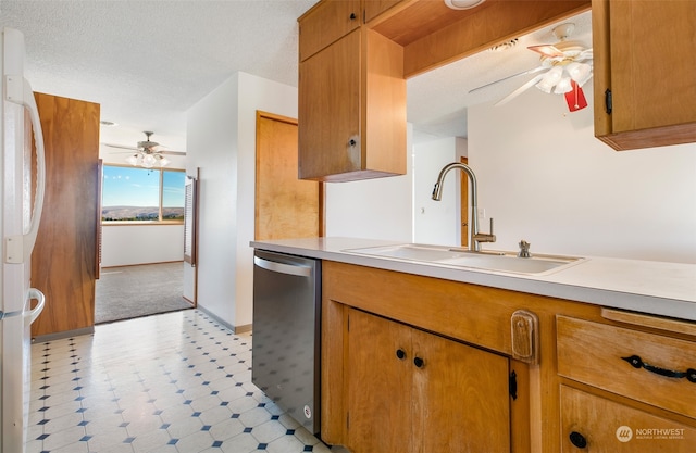 kitchen featuring white refrigerator, a textured ceiling, ceiling fan, stainless steel dishwasher, and sink