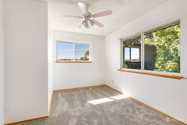 carpeted empty room with a textured ceiling and ceiling fan