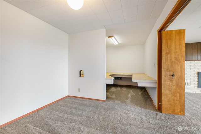 unfurnished bedroom featuring a brick fireplace and carpet flooring