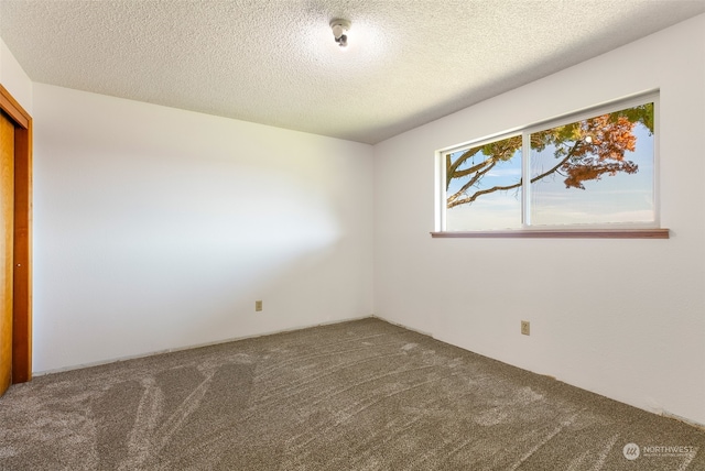 carpeted spare room with a textured ceiling