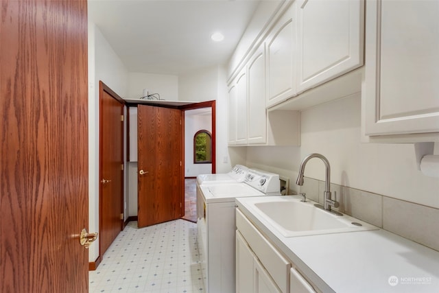 clothes washing area with cabinets, independent washer and dryer, and sink