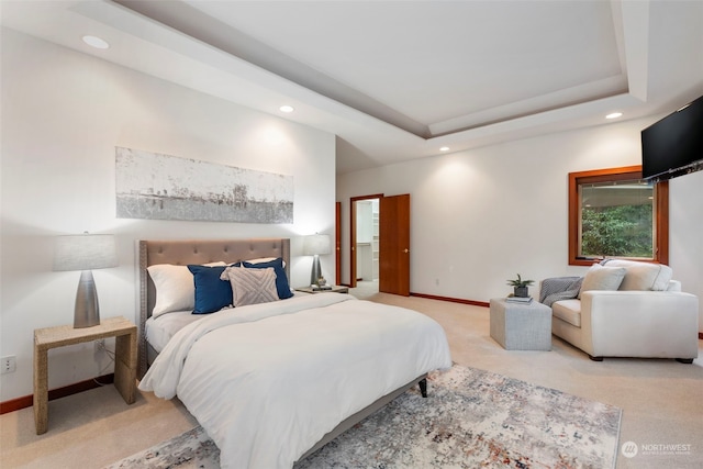 bedroom featuring a raised ceiling and light carpet