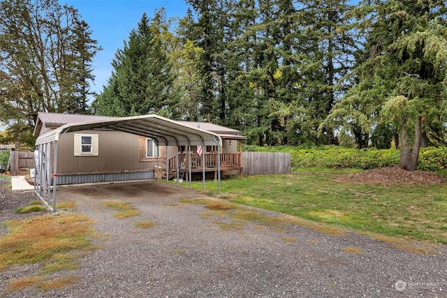 manufactured / mobile home with a wooden deck, a front lawn, and a carport