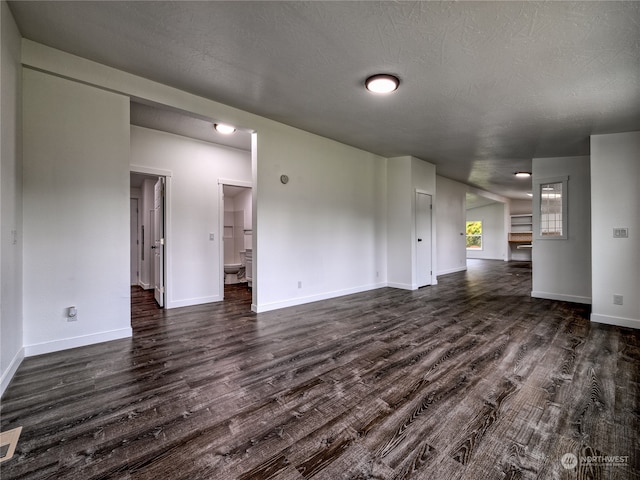 unfurnished living room featuring a textured ceiling and dark wood-type flooring