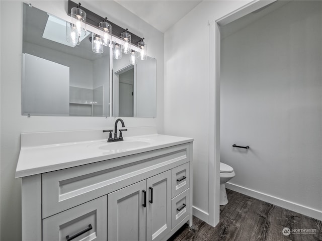 bathroom featuring vanity, hardwood / wood-style floors, and toilet