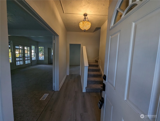 entrance foyer with french doors, dark wood-type flooring, and a textured ceiling