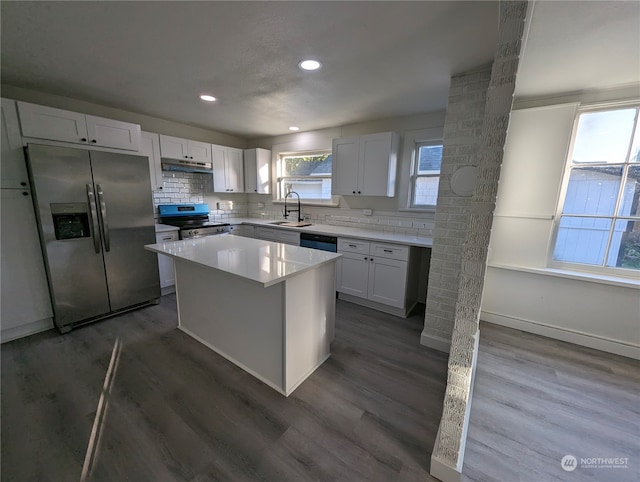 kitchen featuring white cabinets, a kitchen island, dark hardwood / wood-style flooring, and appliances with stainless steel finishes