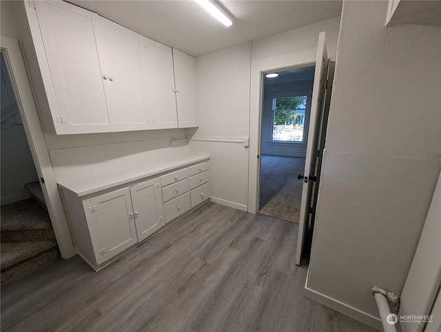 interior space with light wood-type flooring and white cabinetry