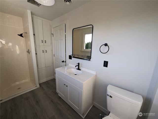 bathroom featuring a shower, hardwood / wood-style floors, vanity, and toilet