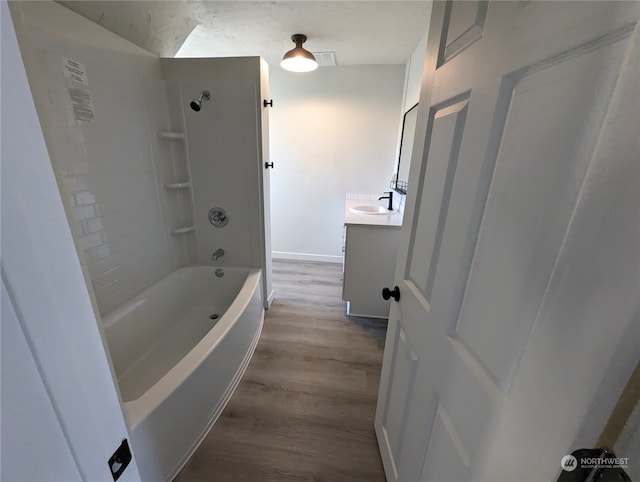 bathroom with hardwood / wood-style floors, vanity, and shower / bathtub combination