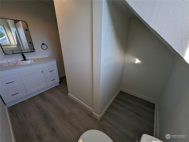 bathroom with hardwood / wood-style floors, vanity, and toilet