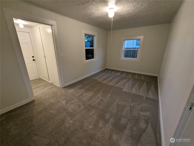 carpeted empty room with a textured ceiling