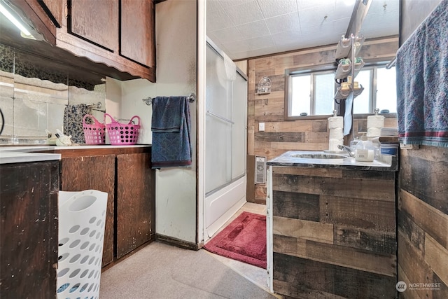 bathroom featuring wooden walls, vanity, and bathtub / shower combination