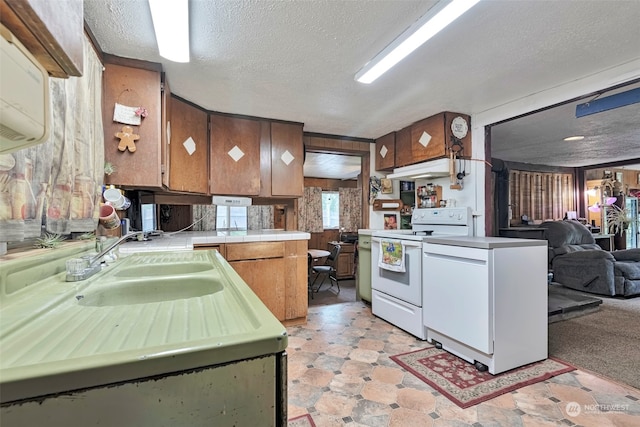 kitchen featuring a textured ceiling, light carpet, sink, and electric range