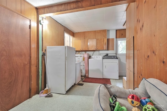 washroom featuring light carpet, separate washer and dryer, and wooden walls