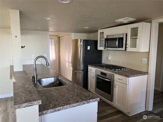 kitchen featuring stainless steel appliances, white cabinets, sink, and dark hardwood / wood-style flooring